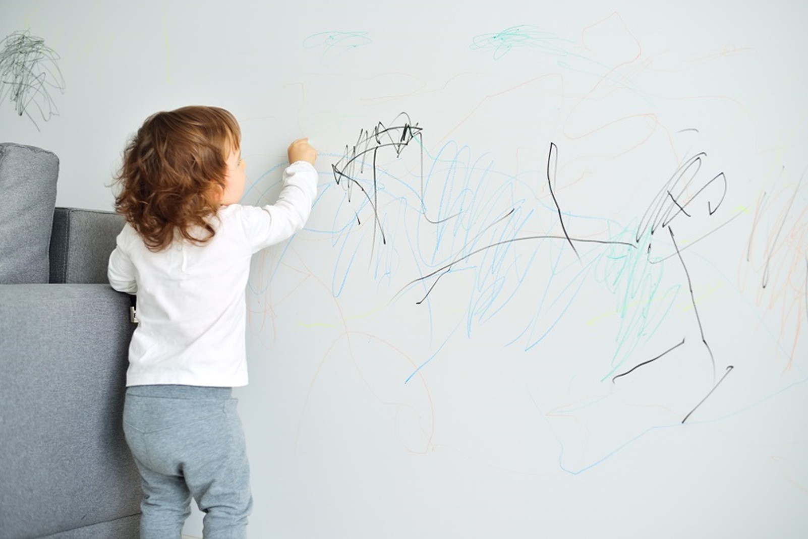 A child writing on the board with a pen